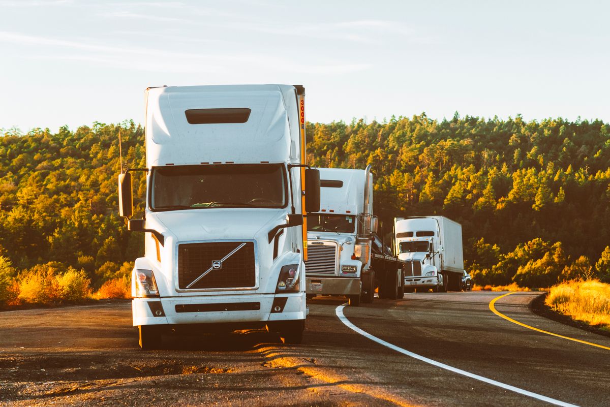 黄昏公路上一列行驶中的货运卡车