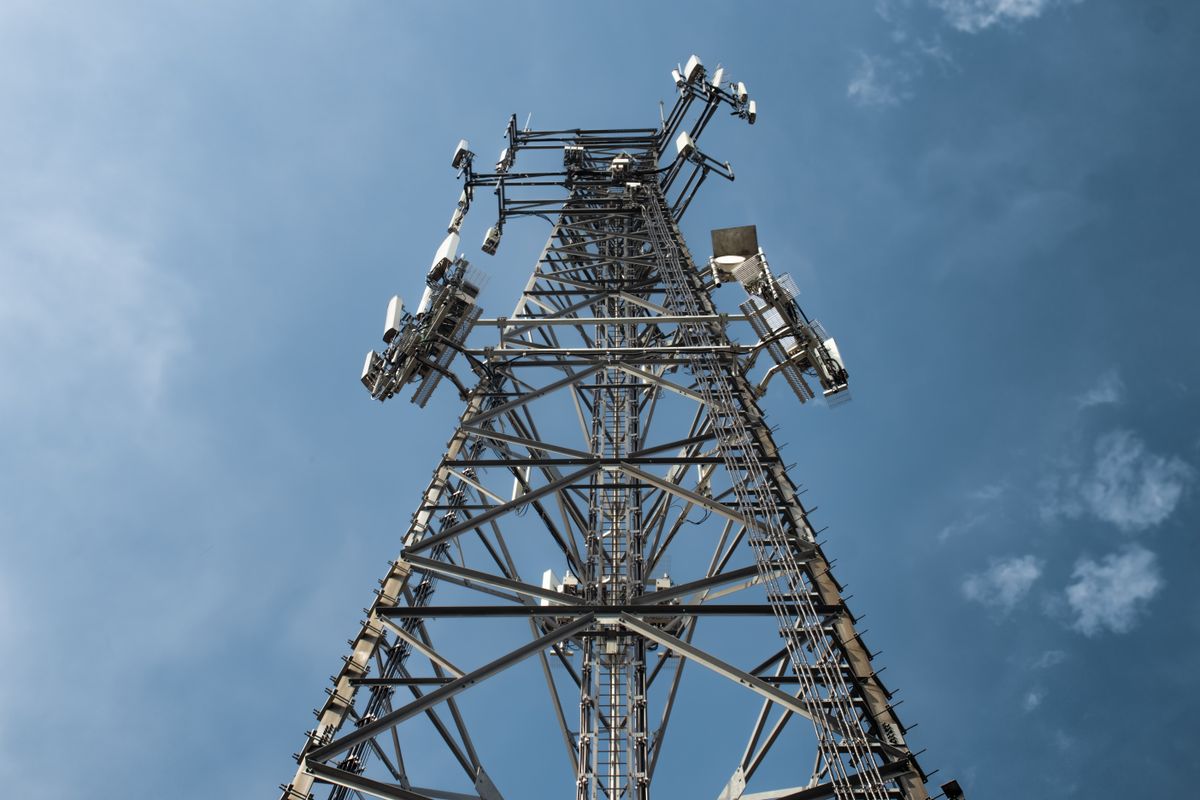 Telecommunications tower with cellular antennas against a blue sky